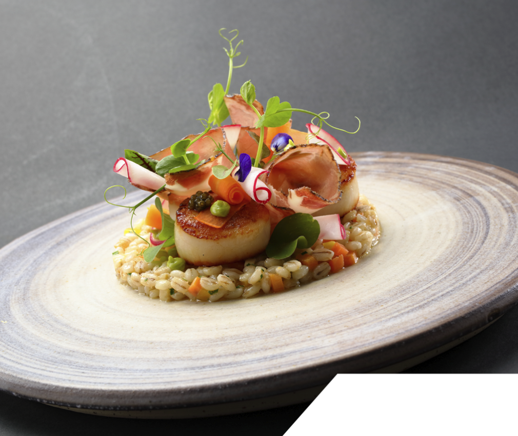 Tower Garden: eine reiche Varietät an Vorspeisen mit traditionellem Südtiroler Geschmack Tower Garden Vorspeisen: Speckscheiben auf Gerstenbett mit Radieschenscheiben und Erbsensprossen.